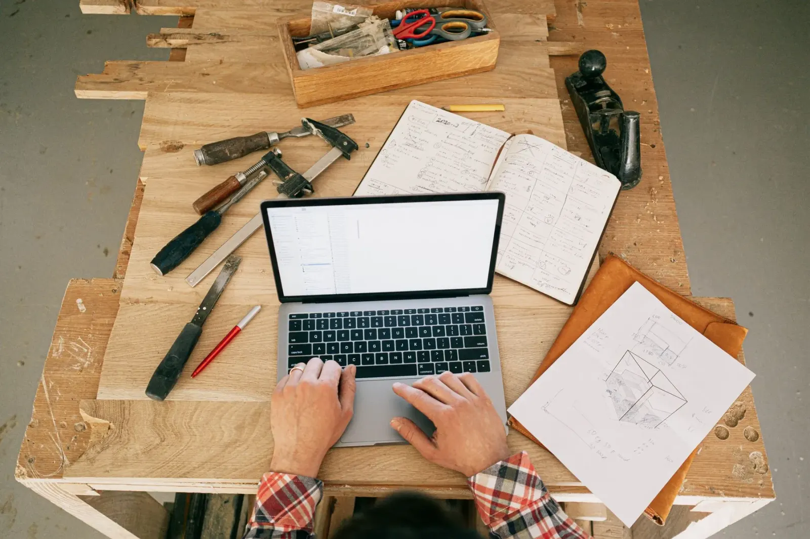 Laptop en plannen op de werkbank van een atelier